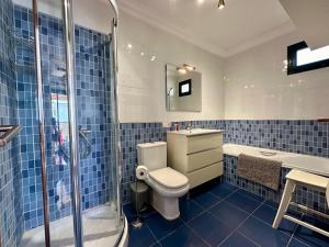 a blue tiled bathroom with a toilet and a shower at Summer Dreams in Costa Teguise