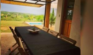 a black table with chairs and a view of a pool at Cabaña Snowflakes in Villa Yacanto +10 photos