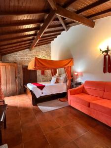 a bedroom with a bed and a red couch at Casas do Rio in Cossourado