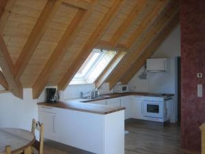 a kitchen with white cabinets and a large window at Au Jardin des 4 Saisons in Eckwersheim