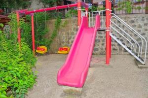a pink slide in a playground in a yard at ST Apart in Pelitli
