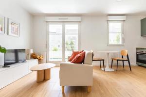 a living room with a couch and a table at Appartement cosy avec terrasse proche de Paris in Saint-Denis