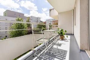 a balcony with a table and chairs on a building at Appartement cosy avec terrasse proche de Paris in Saint-Denis