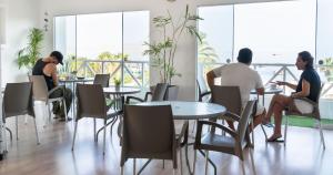 a group of people sitting at tables in a restaurant at Hostal Los Frayles in Paracas