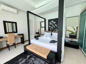 - une chambre avec un lit et un grand miroir dans l'établissement Aromdee 2 Villa by G Estate Phuket, à Ban Saiyuan (1) 19 autres photos
