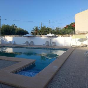 a swimming pool with chairs and umbrellas on a building at Habitalento in El Campello +6 photos