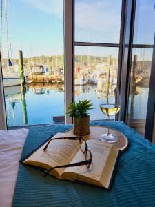 a table with a book and a glass of wine at Floating Sea House SEAESTA in Portorož