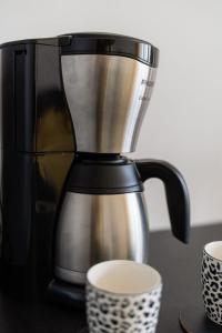 una cafetera sentada en un mostrador junto a dos tazas en Apartament Ania z widokiem na morze w Hotelu Arka, en Kołobrzeg 34 fotos más