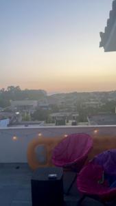 a balcony with two purple pillows and a view of a city at Osmenaj Studios in Vlorë +25 photos