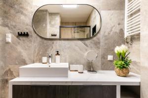 un bagno con un lavandino bianco e uno specchio di Apartament Górski Przystanek a Szklarska Poręba Altre 18 foto