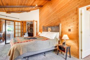 Un dormitorio con una cama y una pared de madera. en Hot Tub and Game Room Spacious Big Bear Lake Cabin, en Big Bear Lake