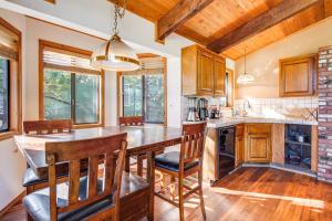 Una cocina con una gran mesa y sillas de madera. en Hot Tub and Game Room Spacious Big Bear Lake Cabin, en Big Bear Lake