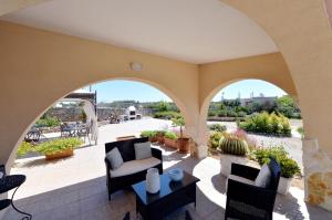 een patio met 2 stoelen en een tafel bij Villa Carola in Gallipoli