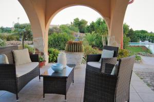 een patio met rieten stoelen en een tafel bij Villa Carola in Gallipoli