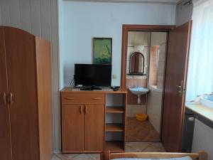 a bathroom with a television on a cabinet with a sink at Willalux in Mielno +50 photos