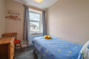 Un dormitorio con una cama con un animal de peluche encima. en Shoemakers House, en Kendal