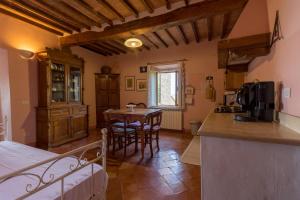 a kitchen and living room with a table and chairs at Le Maribelle in Monticchiello