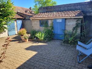 a house with blue doors and a chair in a yard at blu dragonfly in Saint-Aubin-sur-Loire