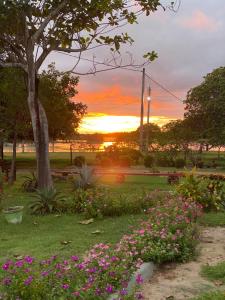 a park with flowers and a sunset in the background at Fazenda Buritizal Grosso in Bonfim