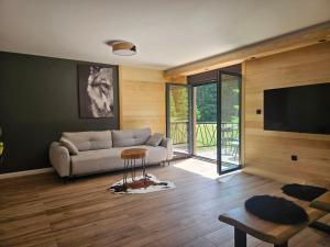 a living room with a couch and a flat screen tv at Forest Fox in Žabljak