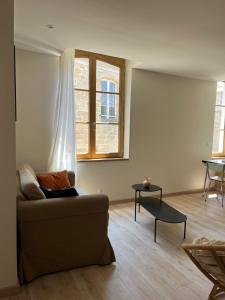 a living room with a couch and a window at Appartement Champollion 2 in Figeac