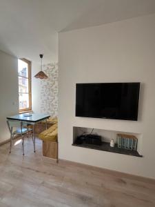 a living room with a flat screen tv on a wall at Appartement Champollion 2 in Figeac