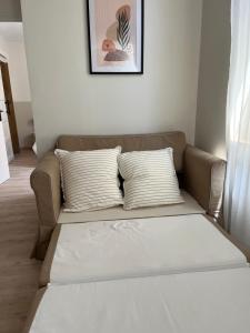 a couch with two pillows in a living room at Appartement Champollion 2 in Figeac