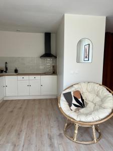 a white kitchen with a round chair in a room at Appartement Champollion 2 in Figeac