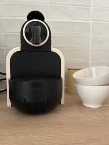 a black robot sitting in a room next to a bowl at Appartement Champollion 2 in Figeac