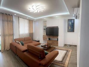 a living room with a couch and a flat screen tv at BB immo dakar in Dakar
