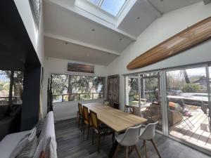 a dining room with a wooden table and chairs at Villa OHANA pour 8 personnes avec piscine et cuisine d'été. Wifi gratuit in Capbreton