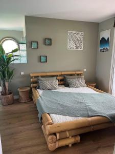 a bedroom with a large bed with a wooden frame at Villa OHANA pour 8 personnes avec piscine et cuisine d'été. Wifi gratuit in Capbreton
