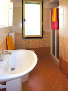 ビビオーネにあるAppartamenti Doraのバスルーム(白い洗面台、窓付)