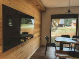 a dining room with a large window and a table at Forest Fox in Žabljak