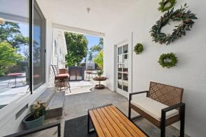 a porch with a bench and chairs on a house at The Cozy Haven Retreat in Novato