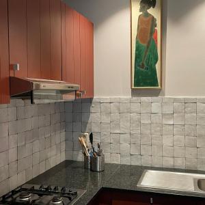 a kitchen with a stove and a painting on the wall at The Cottage in Merelbeke