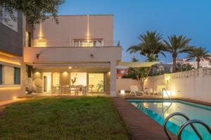 a villa with a swimming pool at night at Villa Helios Aguadulce Almeria in Roquetas de Mar