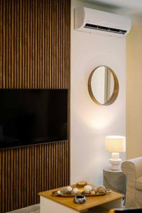 ein Wohnzimmer mit Flachbildfernseher und Tisch in der Unterkunft Icarus & Hermes Luxury Apartments in Corfu + 16 Fotos