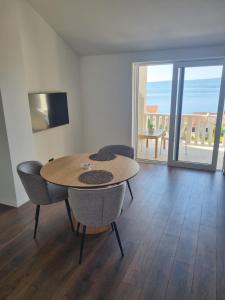 a dining room with a table and chairs and a balcony at Villa Mila in Bol
