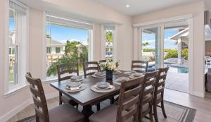 Un comedor con mesa y sillas y ventanas. en Blue Jasmine, en Marco Island