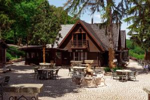 a building with tables and a statue in front of it at Agriturismo La Cerra in Tivoli