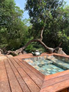 a pool on top of a wooden deck with a tree at A Vadina - Hébergements de charme avec piscine & spa, Porticcio in Porticcio