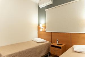 a room with two beds and a projection screen at Hotel Descalvado in Descalvado