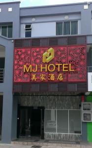 um hotel com uma placa na frente em MJ Hotel em Sibuga