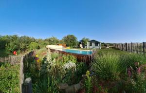 a swimming pool in a garden with flowers at Chalets du Bois de Vache in Le Poët-Célard