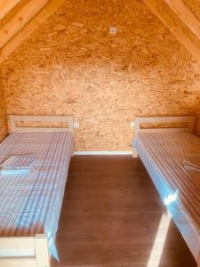 two beds in a room with a wooden ceiling at Kucice za odmor in Plav