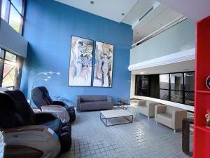 a living room with couches and a blue wall at Flat Manhattan frente ao Dona Lindu in Recife
