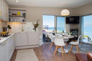 a kitchen and dining room with a view of the ocean at Y Geraint Beach Apartment Aberporth in Aberporth