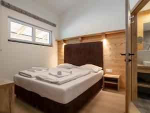 a bedroom with a large bed with white sheets and a window at Apart33 Top 2-13 in Haus im Ennstal