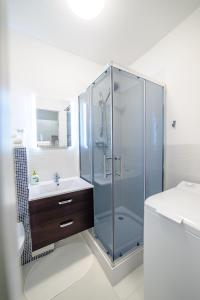 y baño con ducha acristalada y lavamanos. en Apartament Grójecka Korotyńskiego en Varsovia